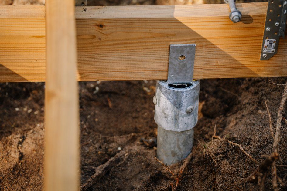 A Metal Post is in the Dirt Under a Wooden Deck — Q-Pile Foundations in Nambour, QLD
