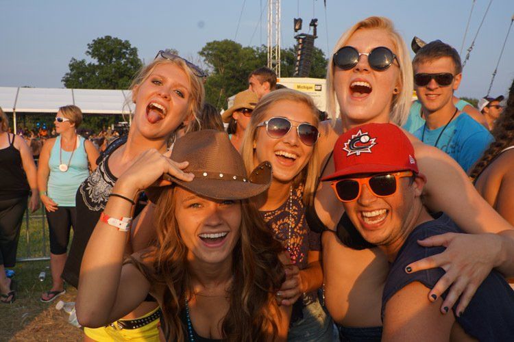 A group of people posing for a picture with one wearing a cowboy hat