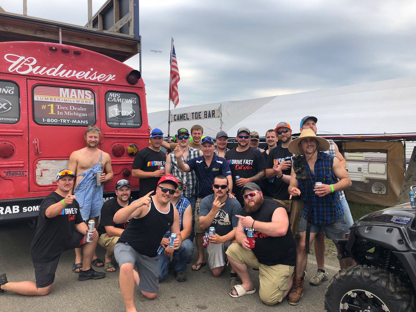 A group of men are posing for a picture in front of a budweiser truck