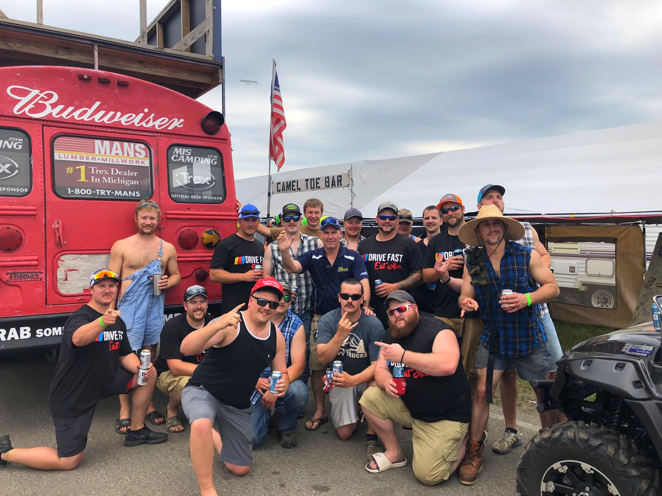 A group of men are posing for a picture in front of a budweiser truck