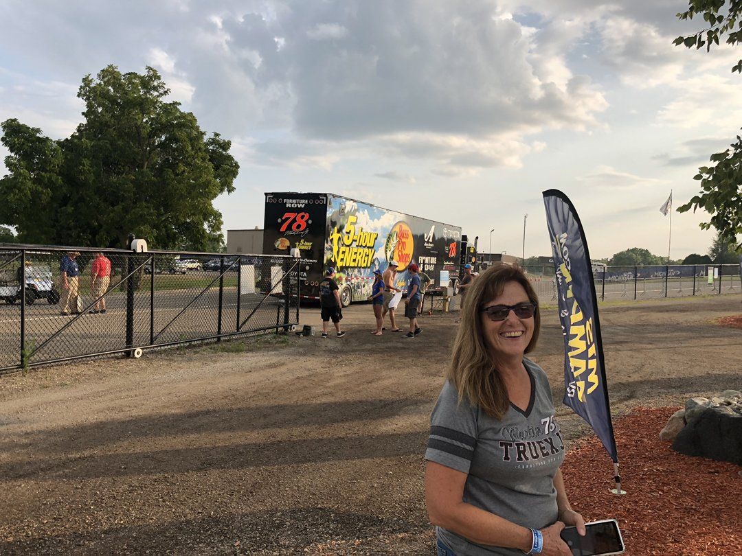 A woman is standing in a parking lot in front of a trailer.