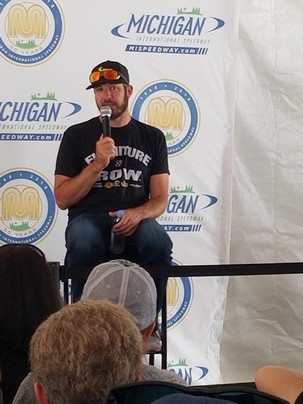 A man is sitting in front of a sign that says michigan