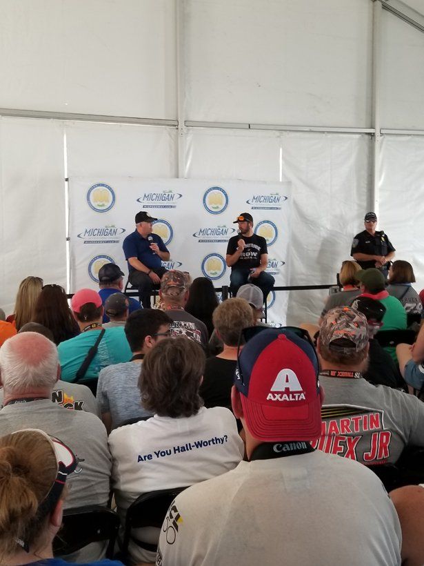 A group of people are sitting in a tent watching a presentation