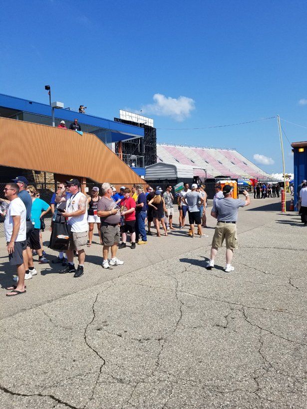 A group of people are standing in a line outside of a building.