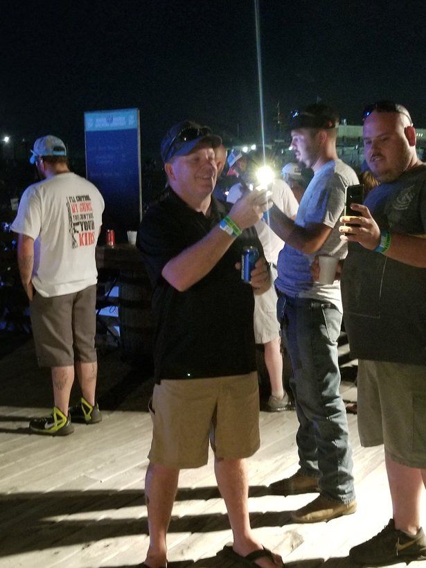 A man taking a picture of another man with a flashlight