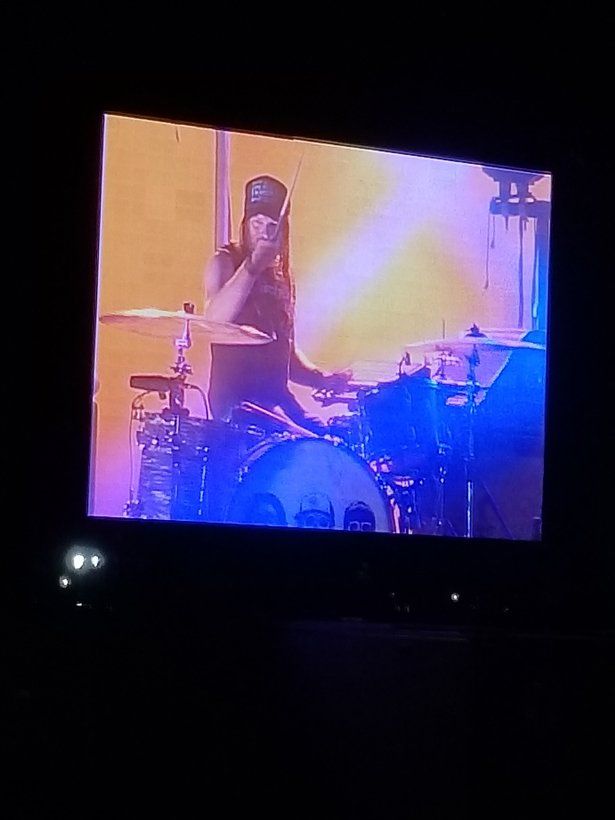 A man is playing drums on a television screen.