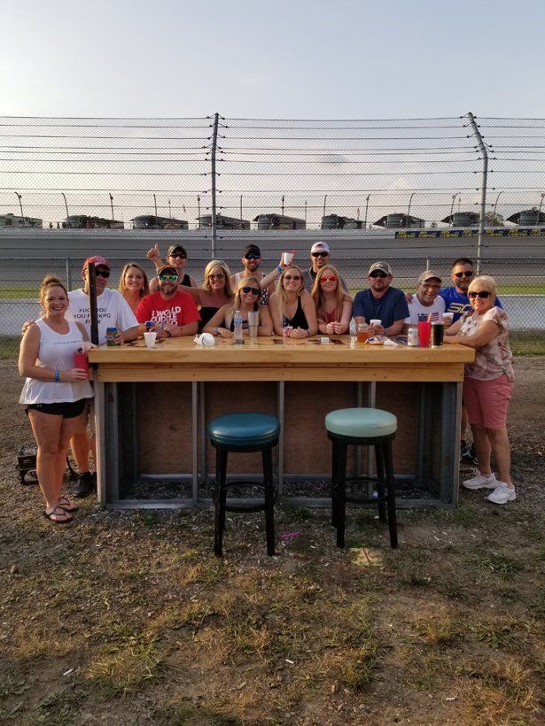 A group of people are posing for a picture in front of a bar.