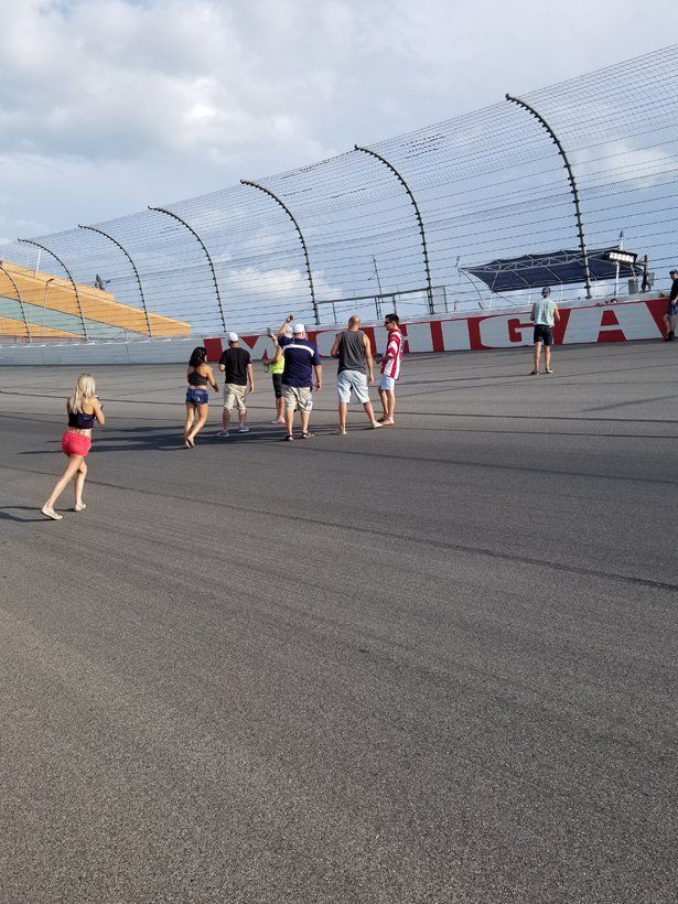 A group of people are walking on a race track.