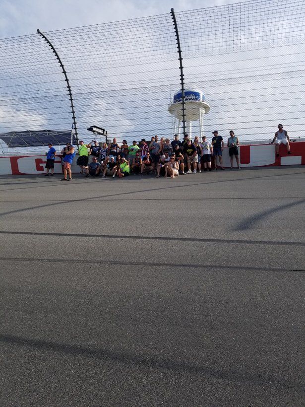 A group of people are standing in front of a race track