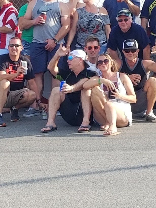 A group of people are posing for a picture on the side of the road.