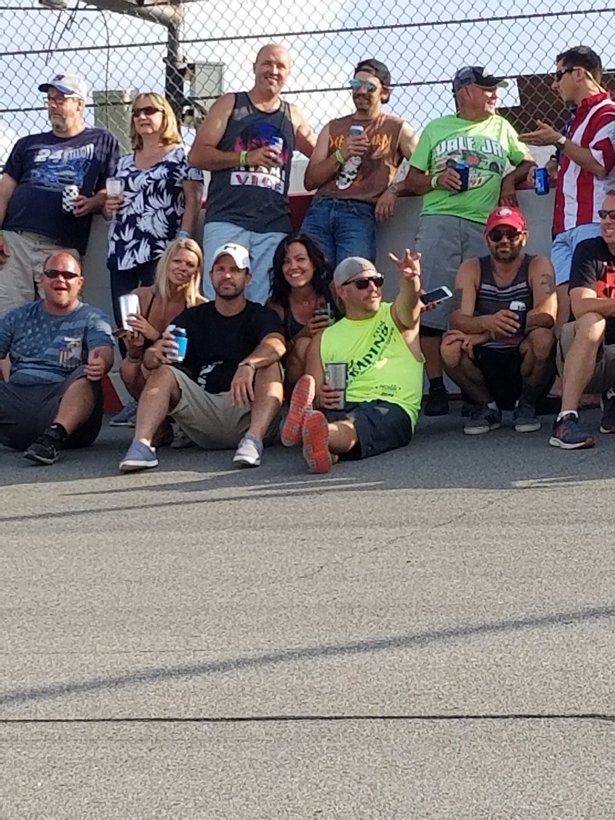 A group of people are posing for a picture while sitting on the ground.