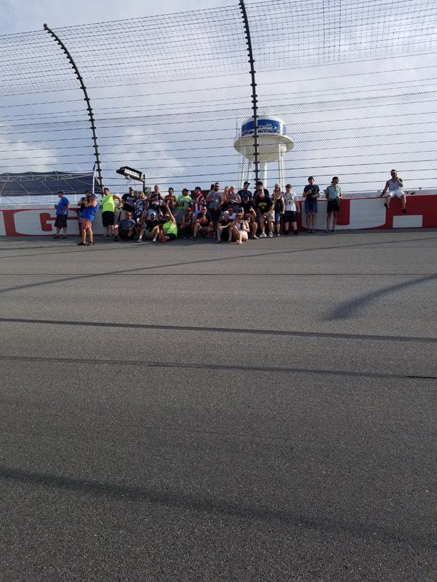 A group of people are sitting on the side of a race track