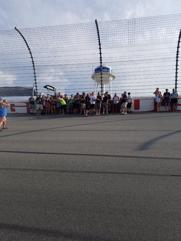 A group of people are standing in front of a race track