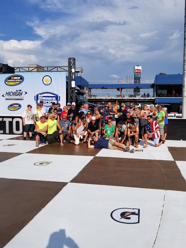 A group of people are posing for a picture in front of a sign that says gatorade