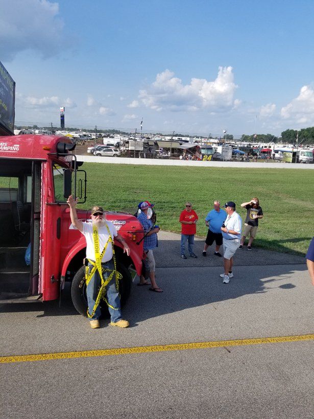 A group of people are standing in front of a red school bus