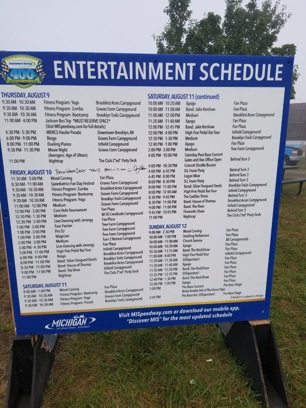 A blue and white sign displays an entertainment schedule
