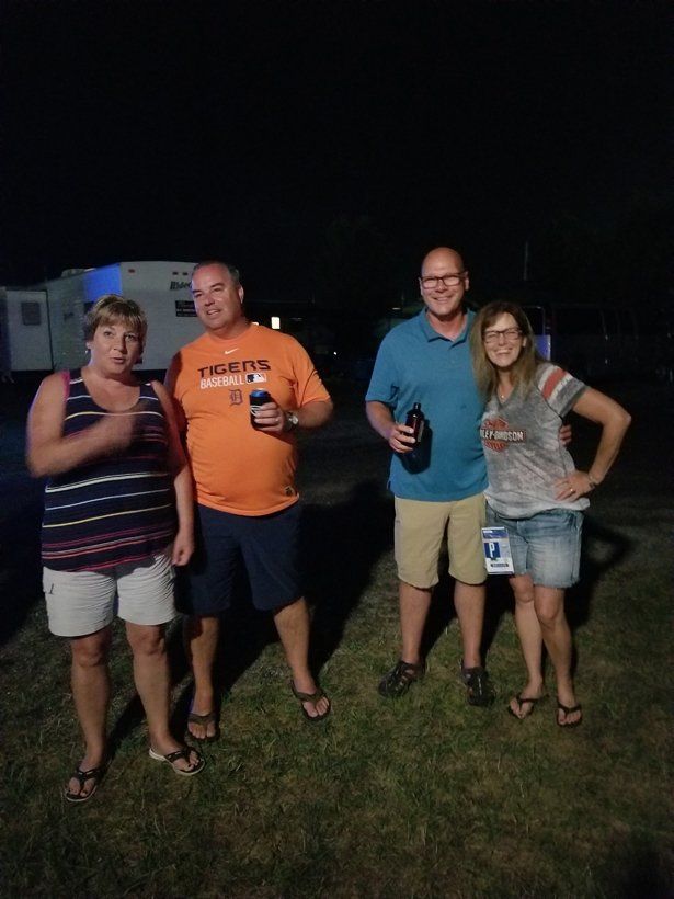A group of people standing next to each other in a field at night.