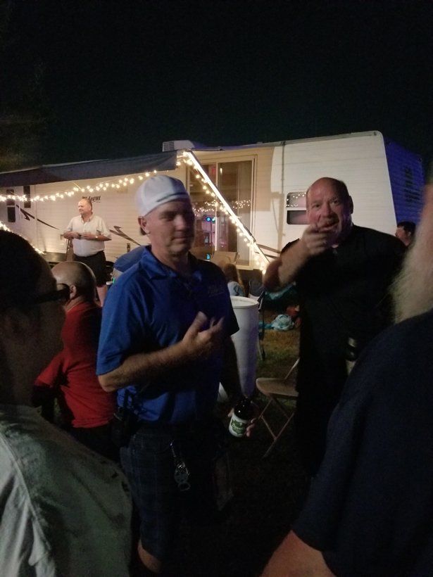A group of people are standing in front of a trailer at night