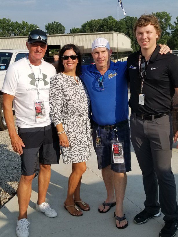 A group of people posing for a picture with one man wearing an under armour shirt