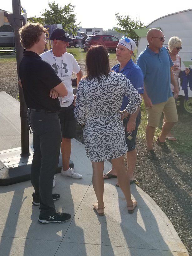 A group of people standing on a sidewalk talking to each other