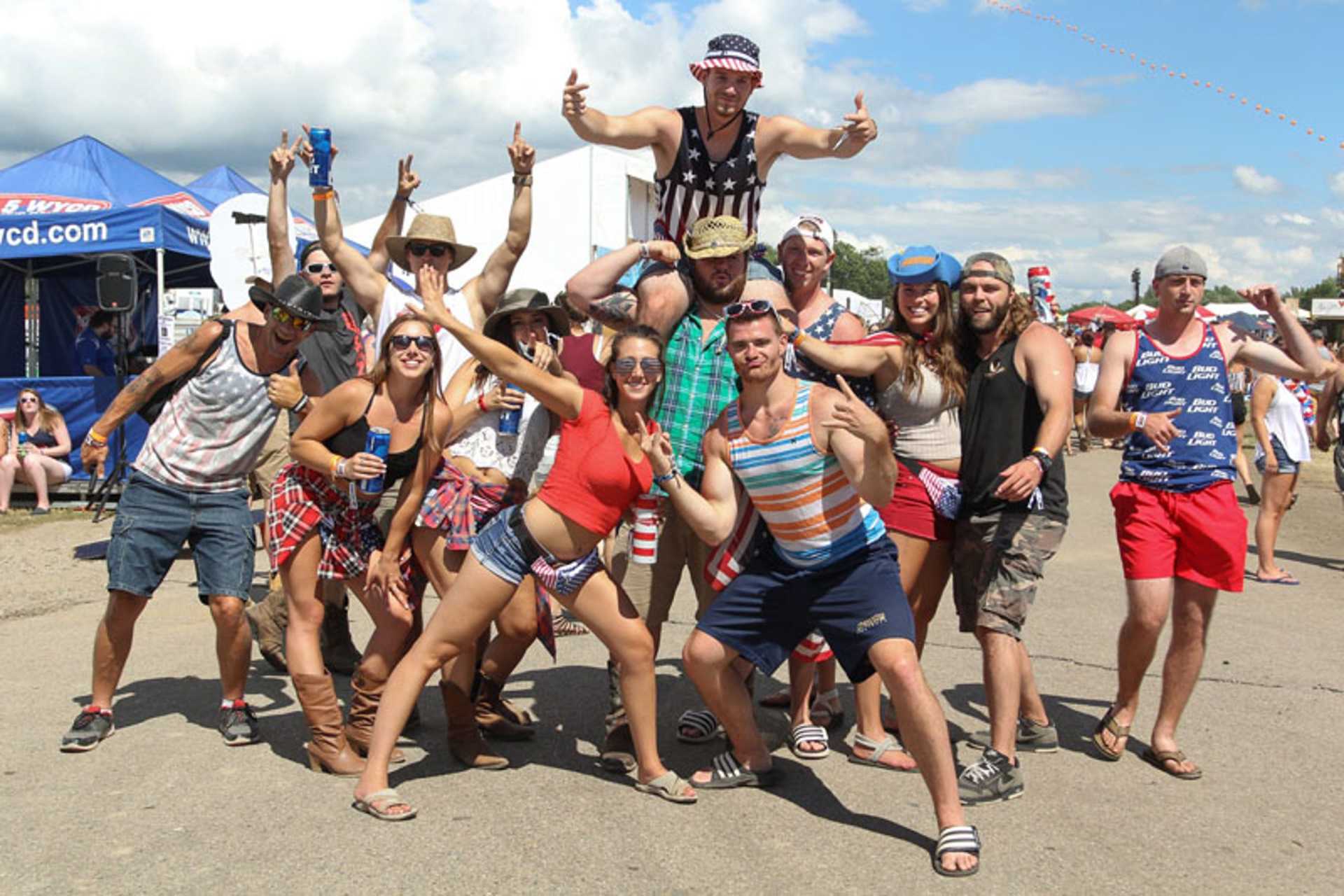 A group of people posing for a picture in front of a red bull tent
