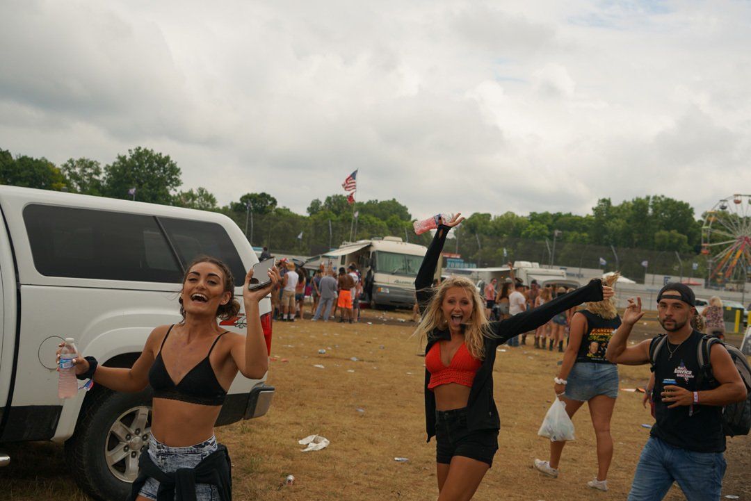 A group of people are standing in a field with their arms in the air.
