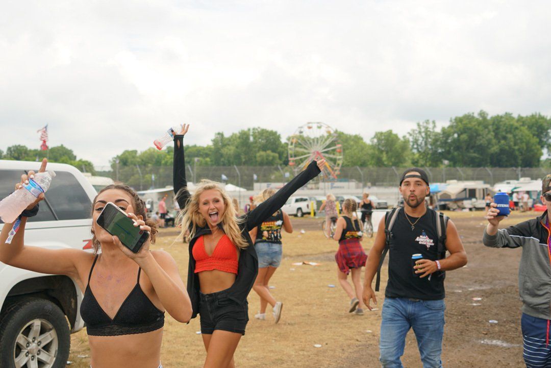 A group of people are standing in a field at a music festival.