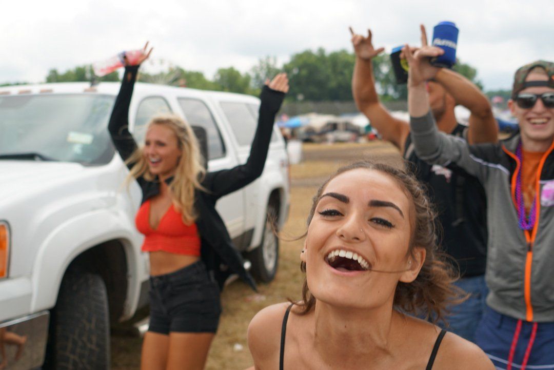 A group of people are standing in front of a white truck.
