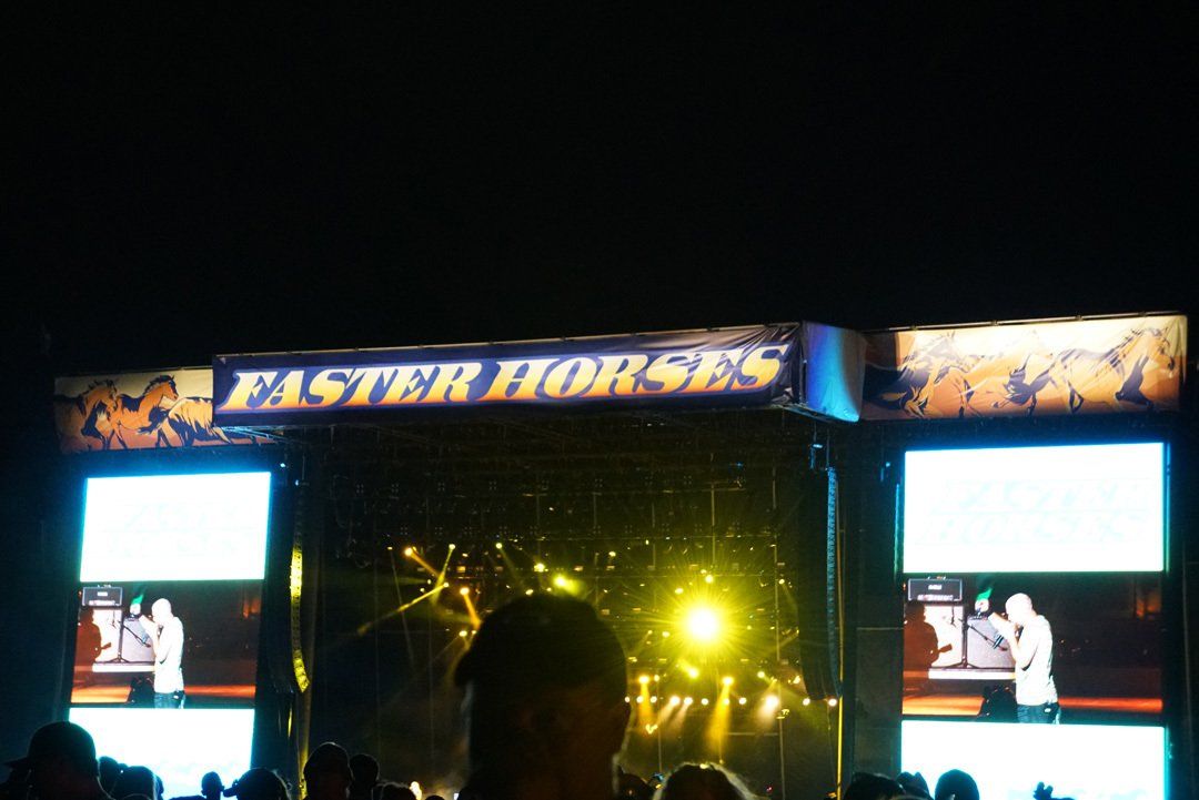 A stage with a banner that says faster horses