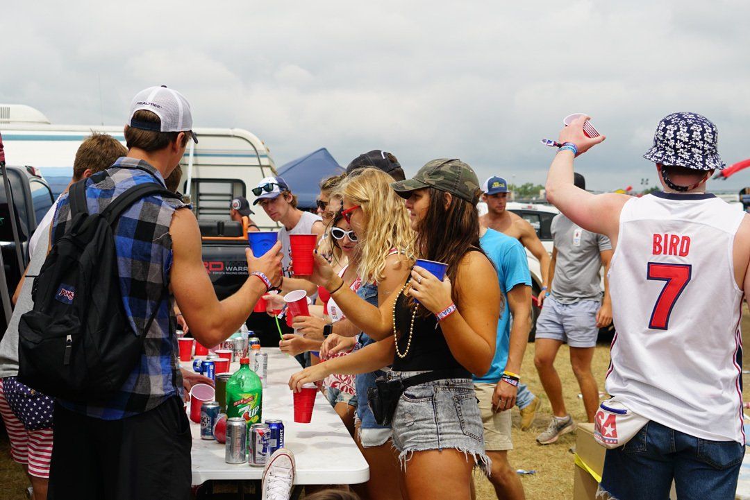A group of people are standing around a table with a man wearing a jersey with the number 7 on it.