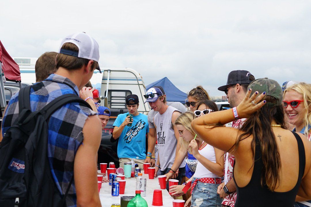 A group of people are standing around a table with red cups.