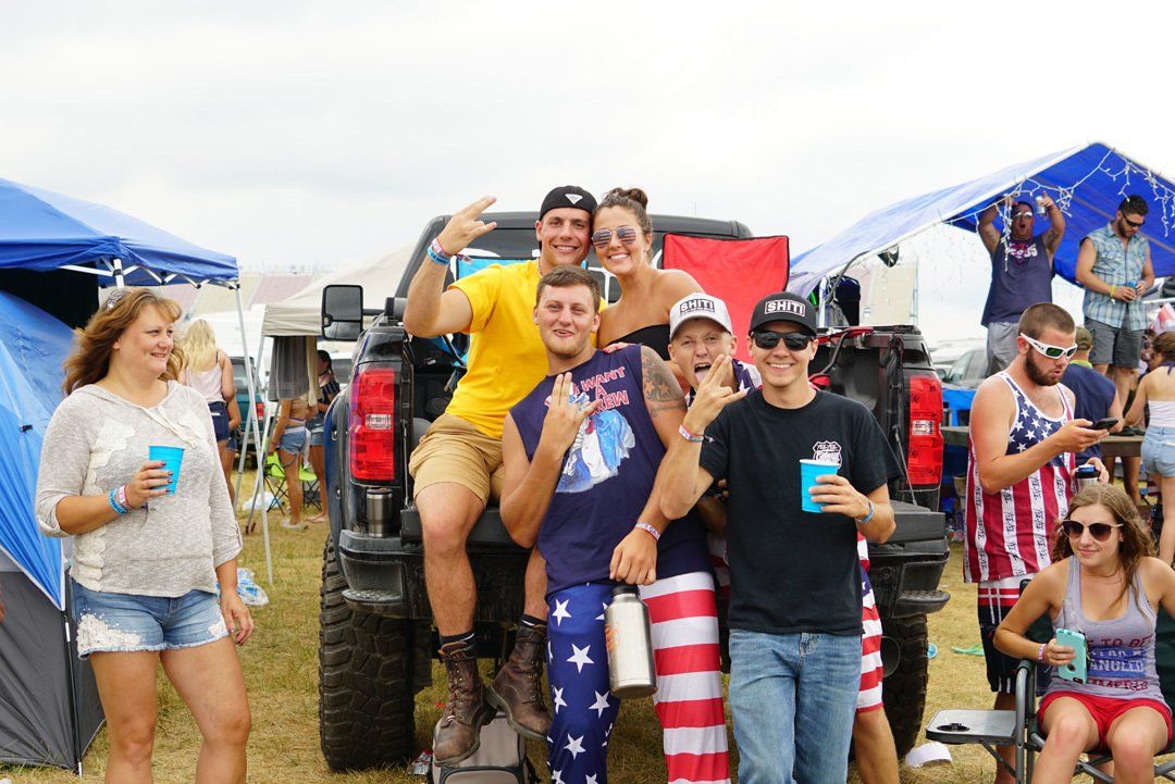 A group of people are posing for a picture in front of a truck.