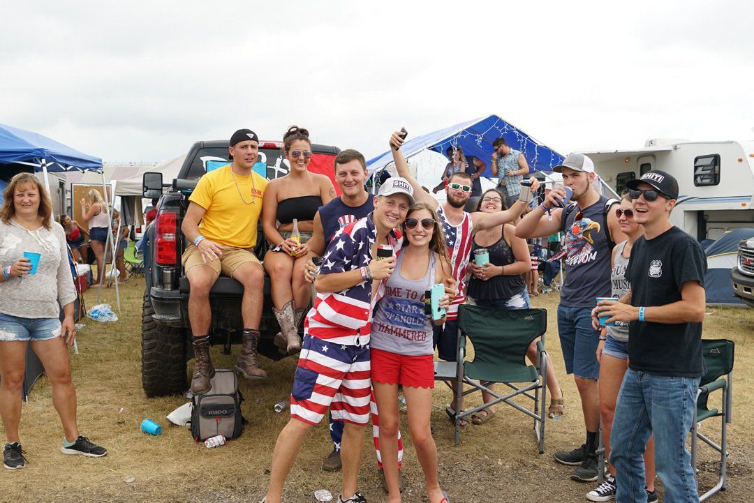 A group of people are posing for a picture in front of a truck.