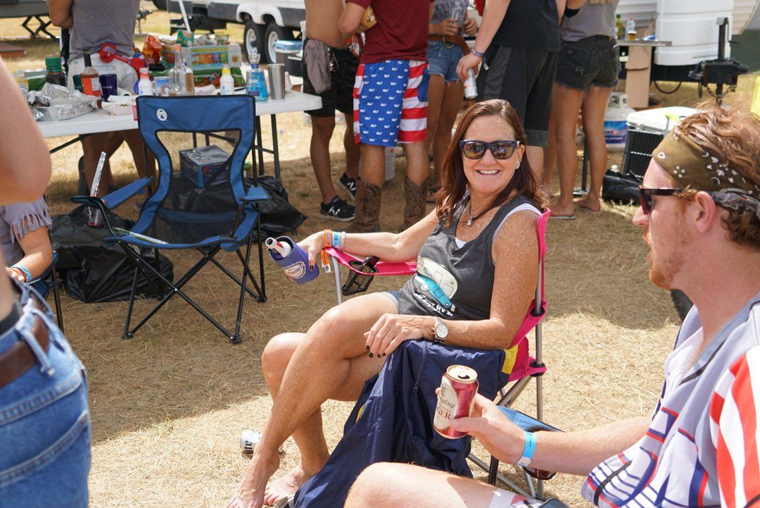 A woman is sitting in a chair holding a can of soda.