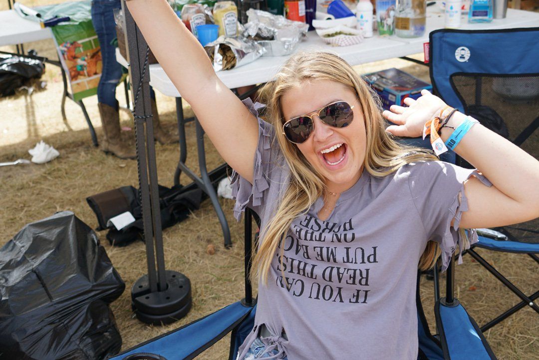 A woman wearing sunglasses and a shirt that says if you can read this put me down