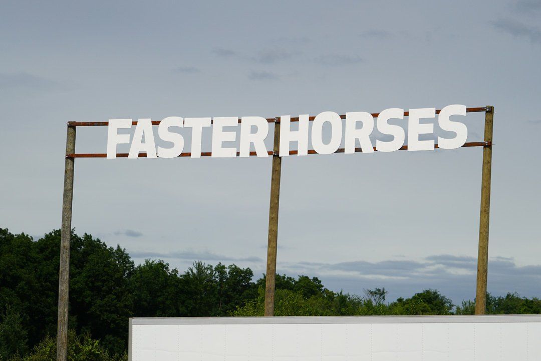 A sign that says faster horses on it