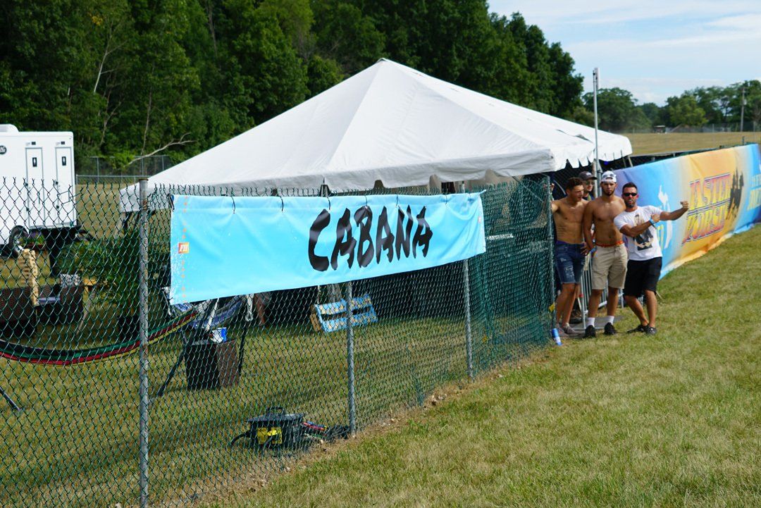 A group of people standing in front of a cabana tent