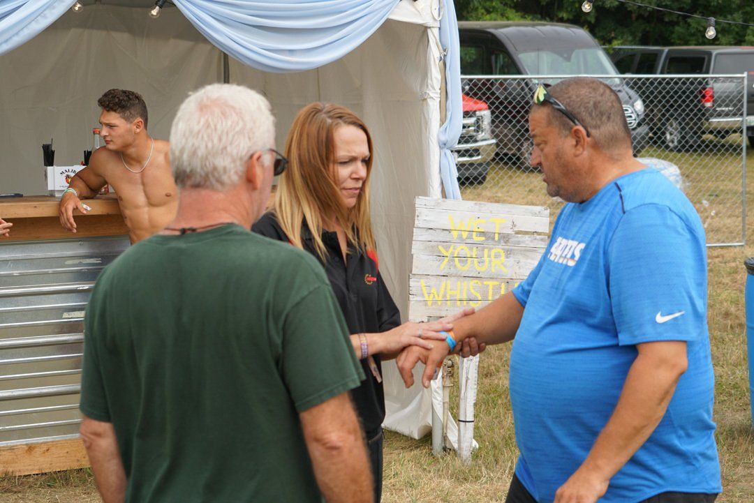 A group of people are standing in front of a tent talking to each other.