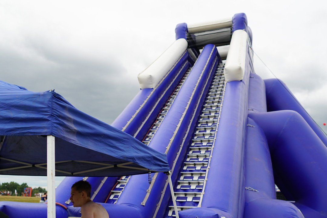 A man stands in front of an inflatable water slide