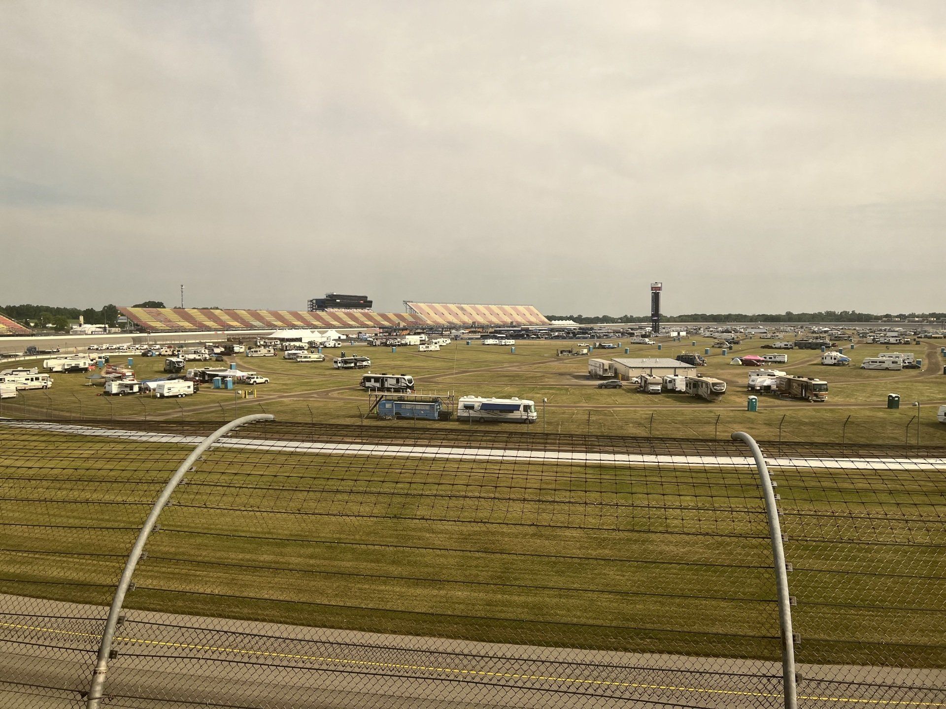 A race track with a lot of cars parked in the grass