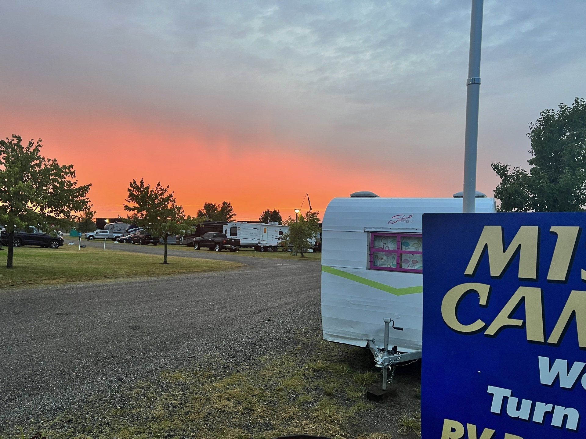 A sign that says ' mt camp ' on it in front of a sunset
