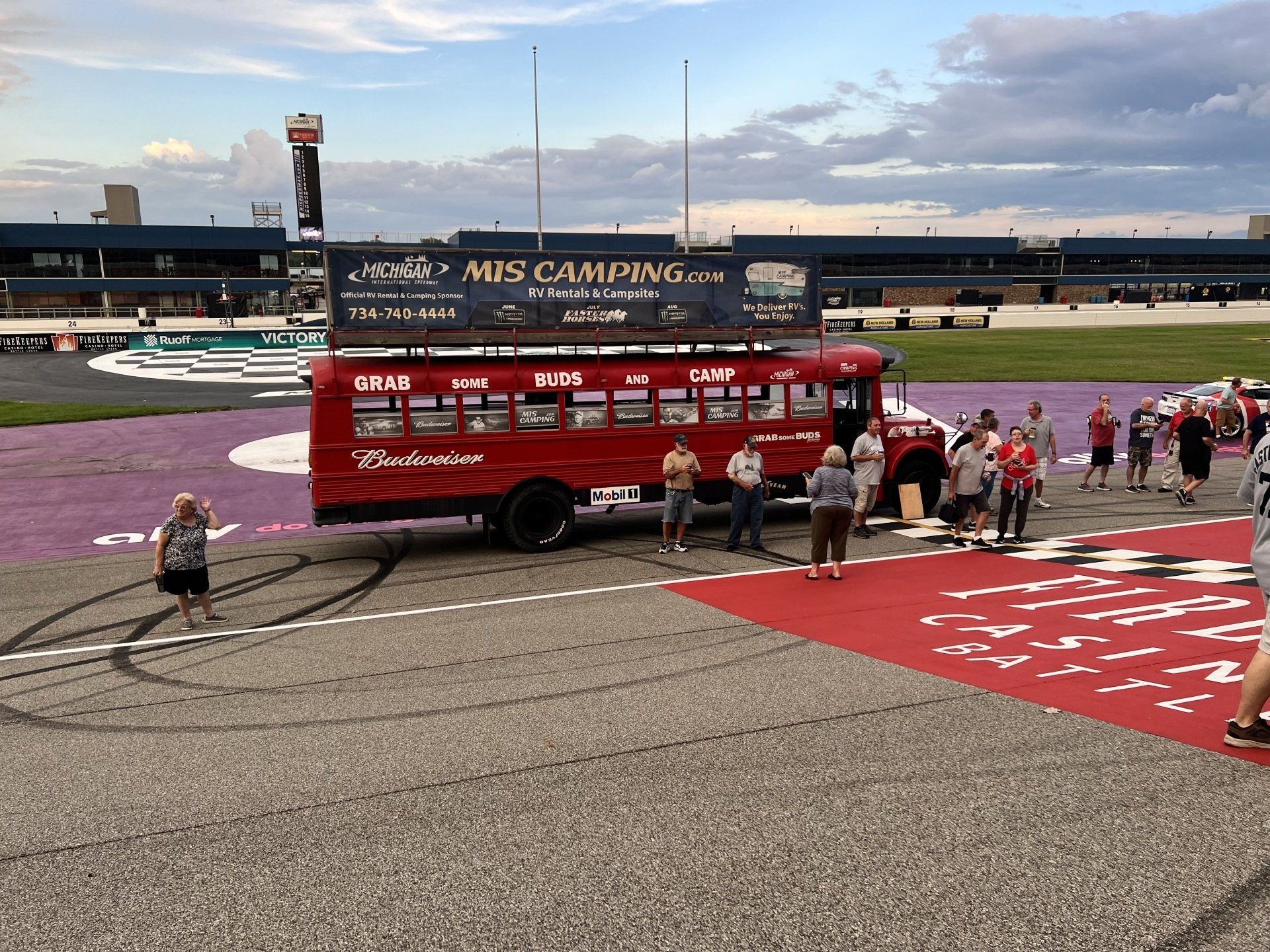 A red bus that says mis camping on the side of it