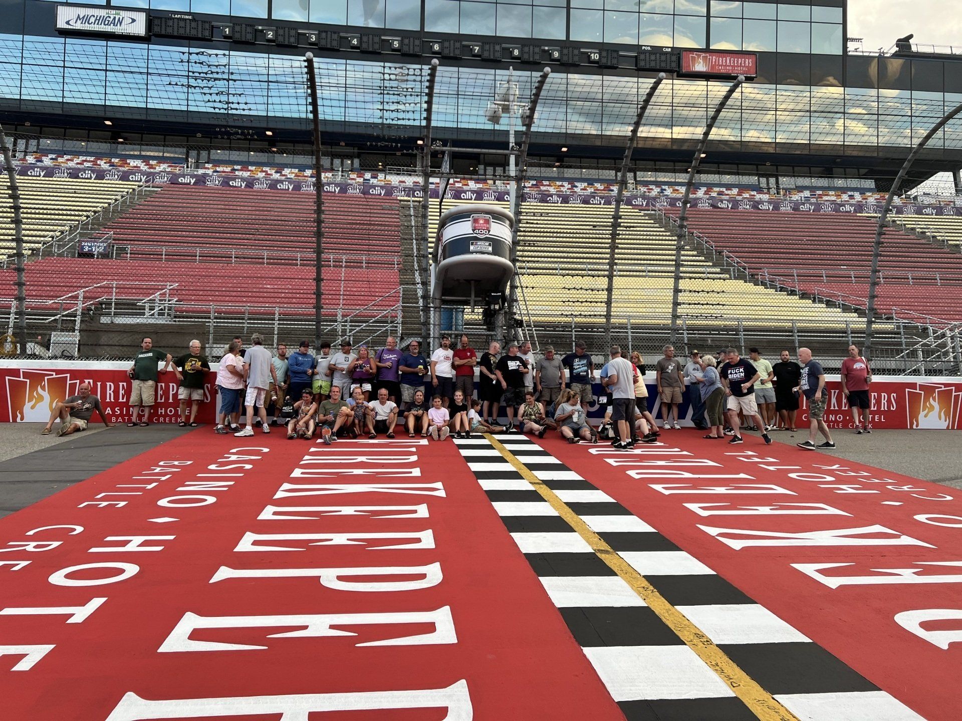 A group of people are posing for a picture in front of a race track.