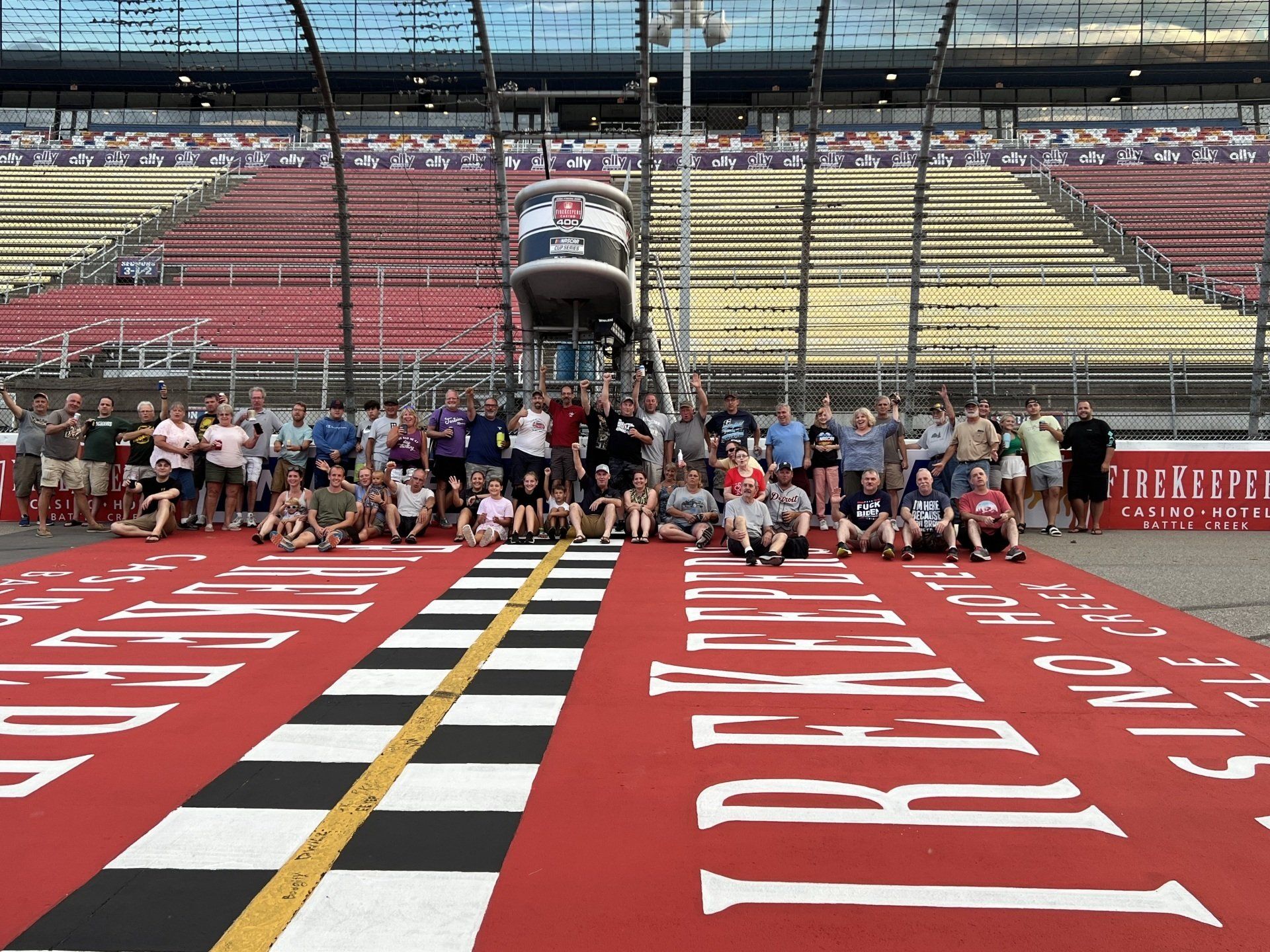 A group of people are posing for a picture on the race track