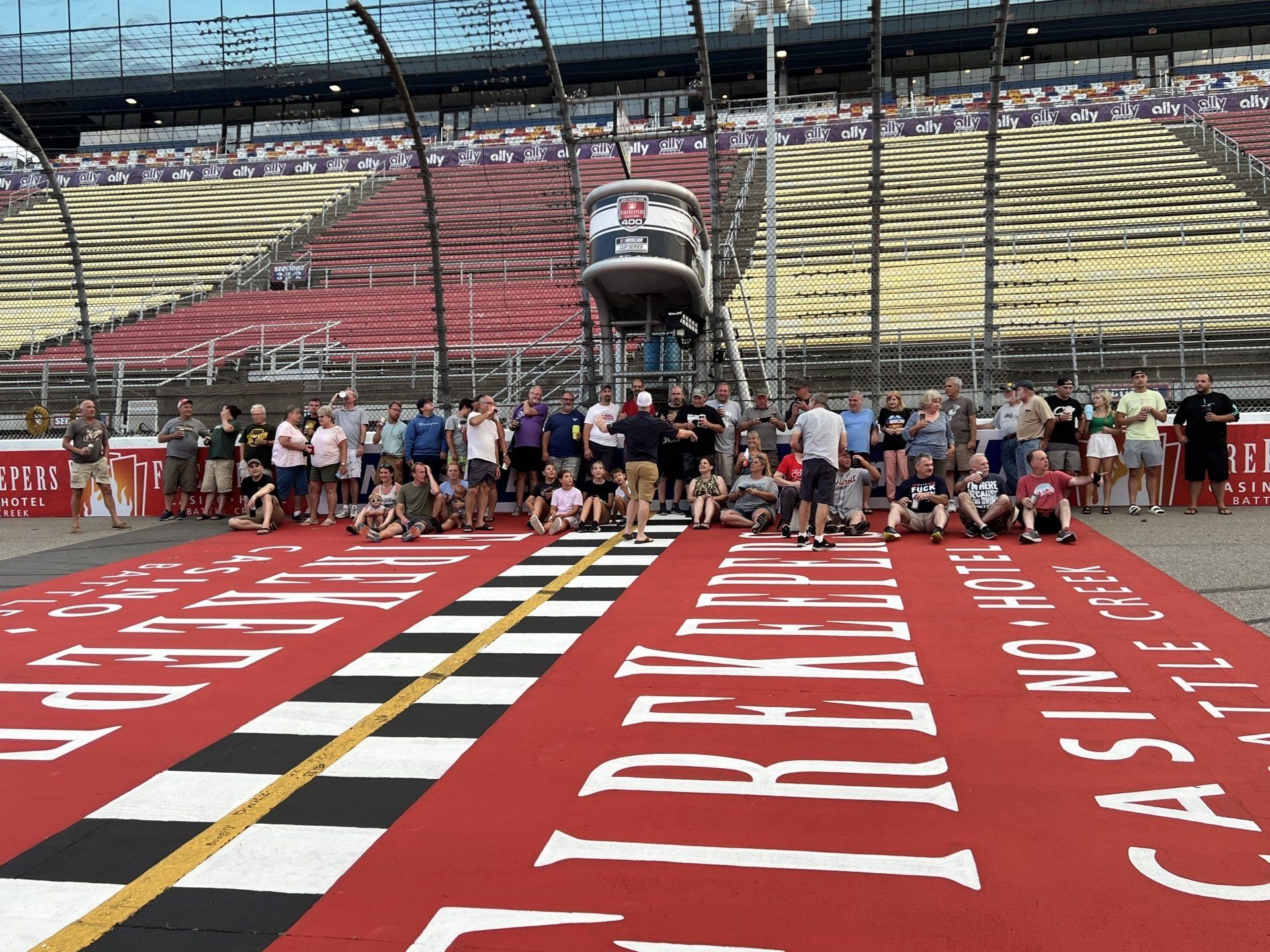 A group of people are posing for a picture on a race track