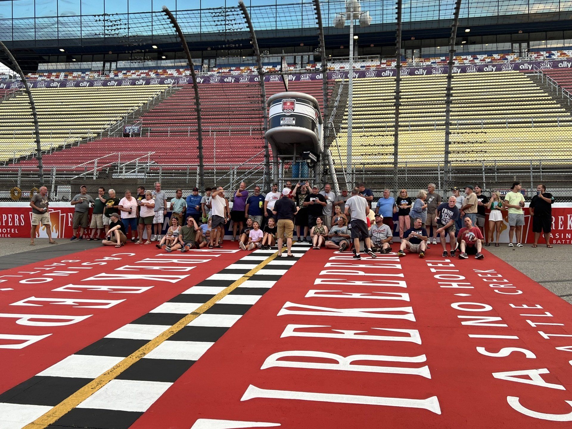 A group of people are posing for a picture on a race track