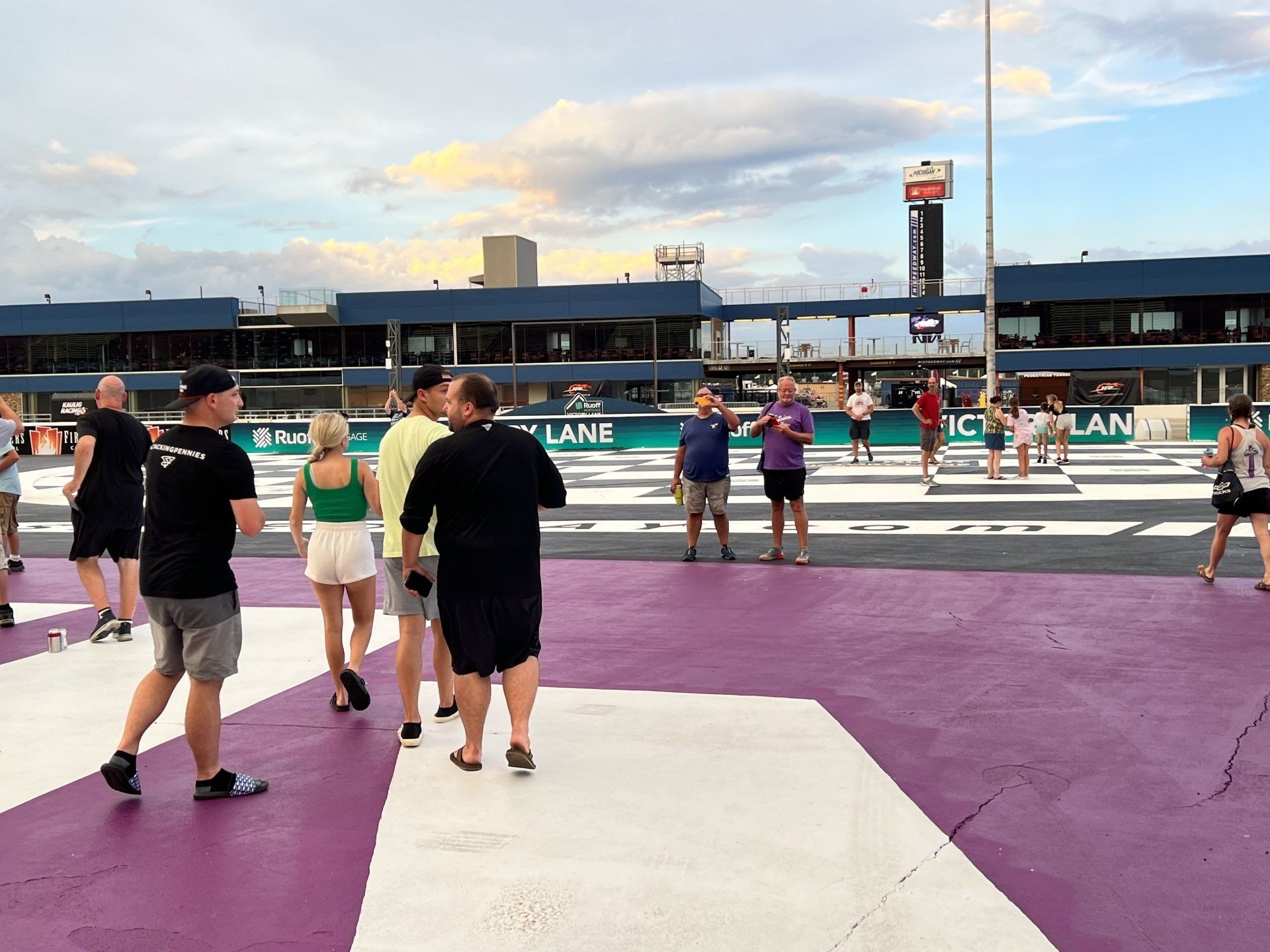 A group of people are walking across a purple and white crosswalk