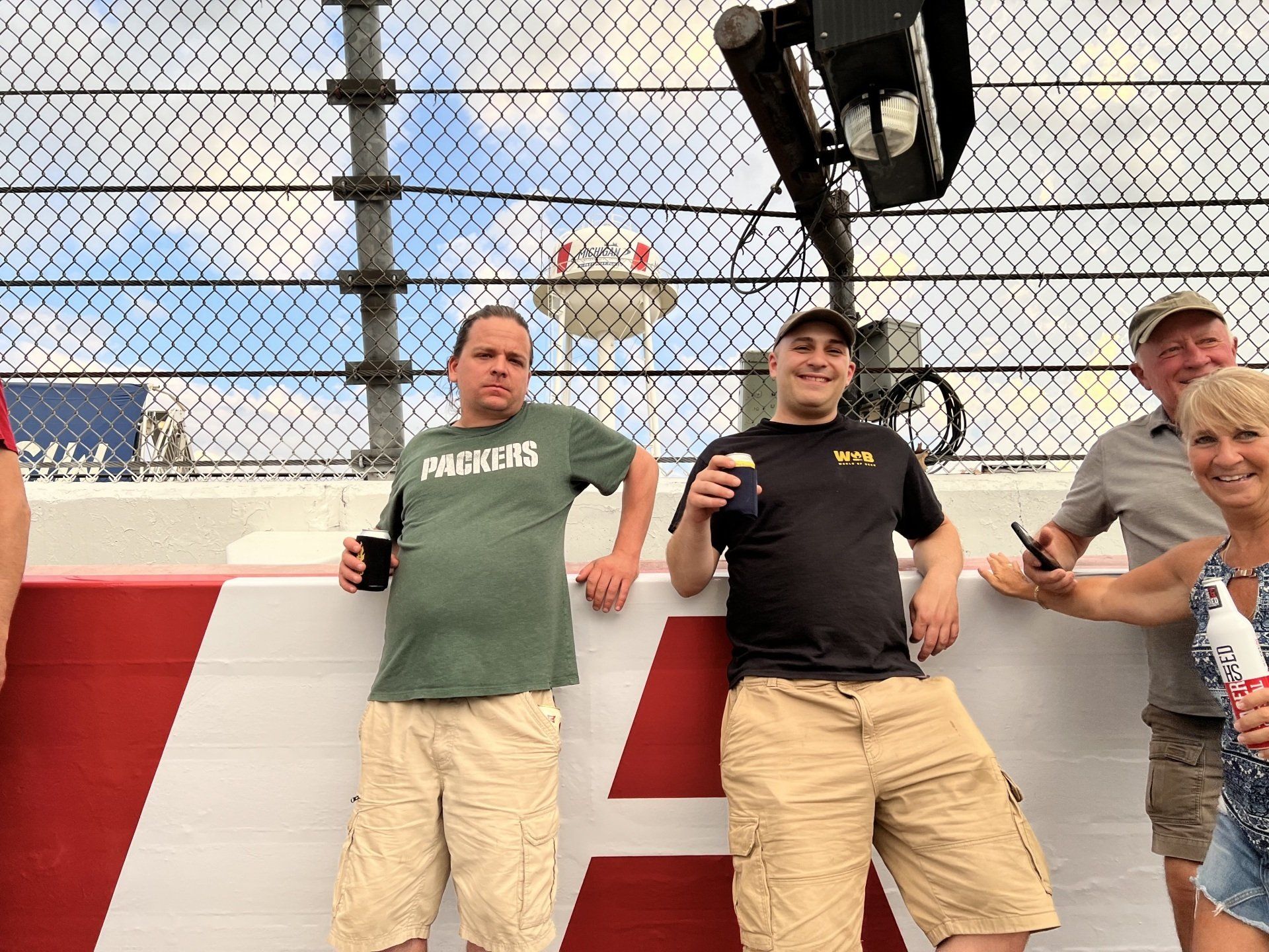 A group of people standing in front of a green bay packers sign