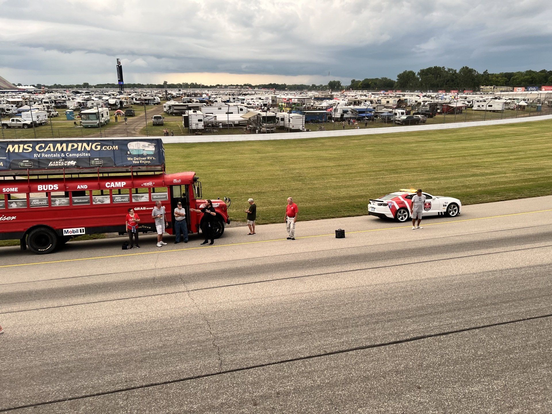 A red bus with a sign on top that says mis camping