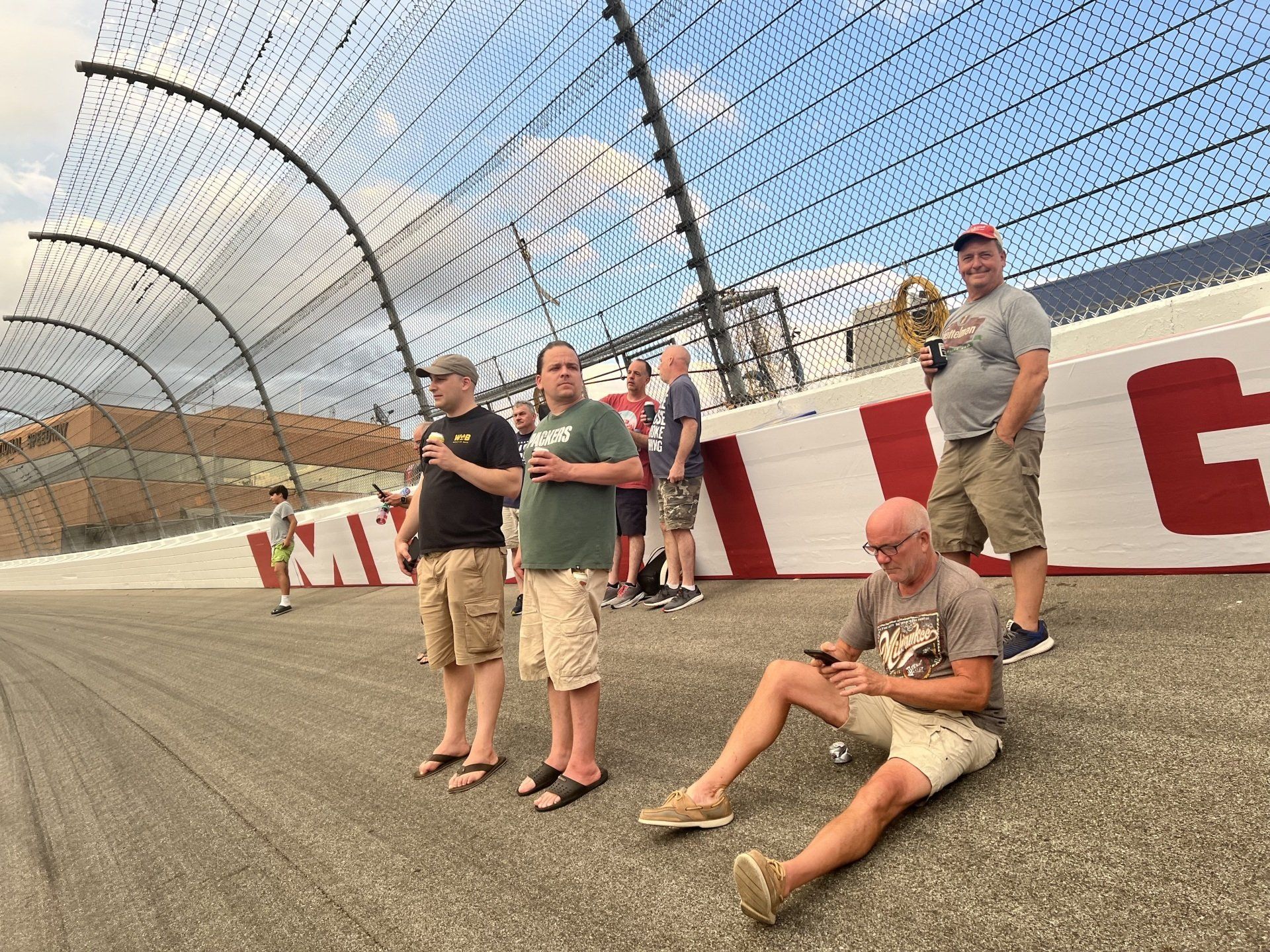 A group of men standing and sitting on a race track
